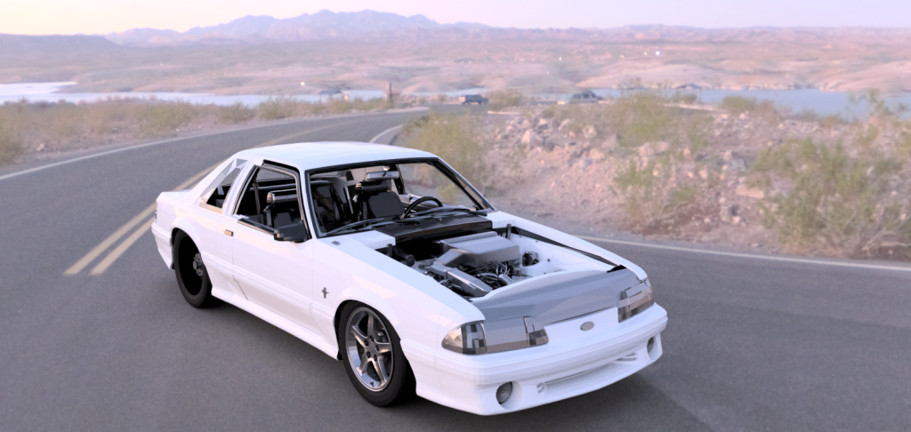 A white Ford Mustang with exposed engine and roll cage drives on a desert road near water, under mountains