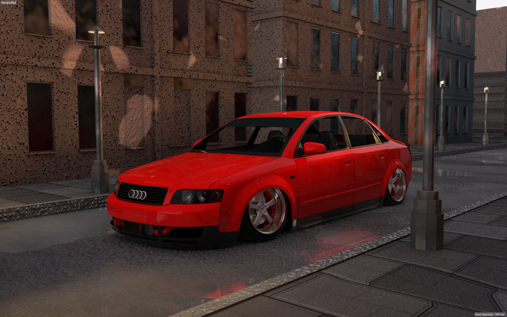 A red Audi sedan with custom wheels and lowered suspension is parked on a city street beside brick buildings