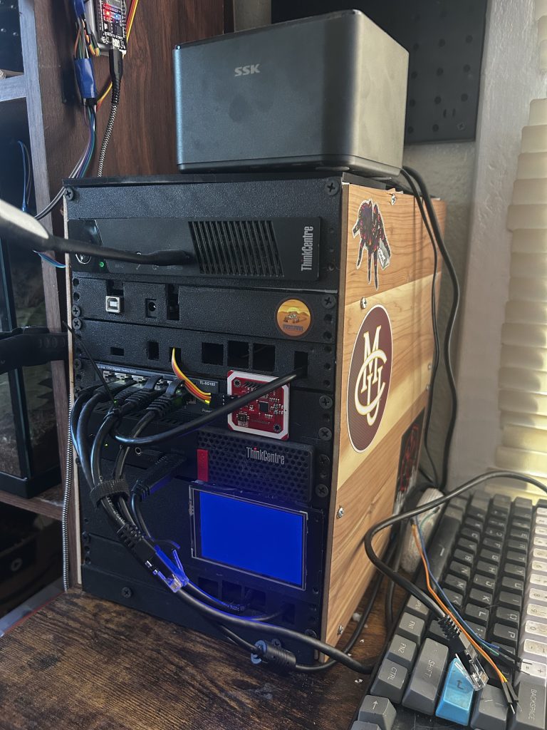 A custom wooden server tower labelled ThinkCentre, stacked with an SSK drive and circuit boards beside a keyboard